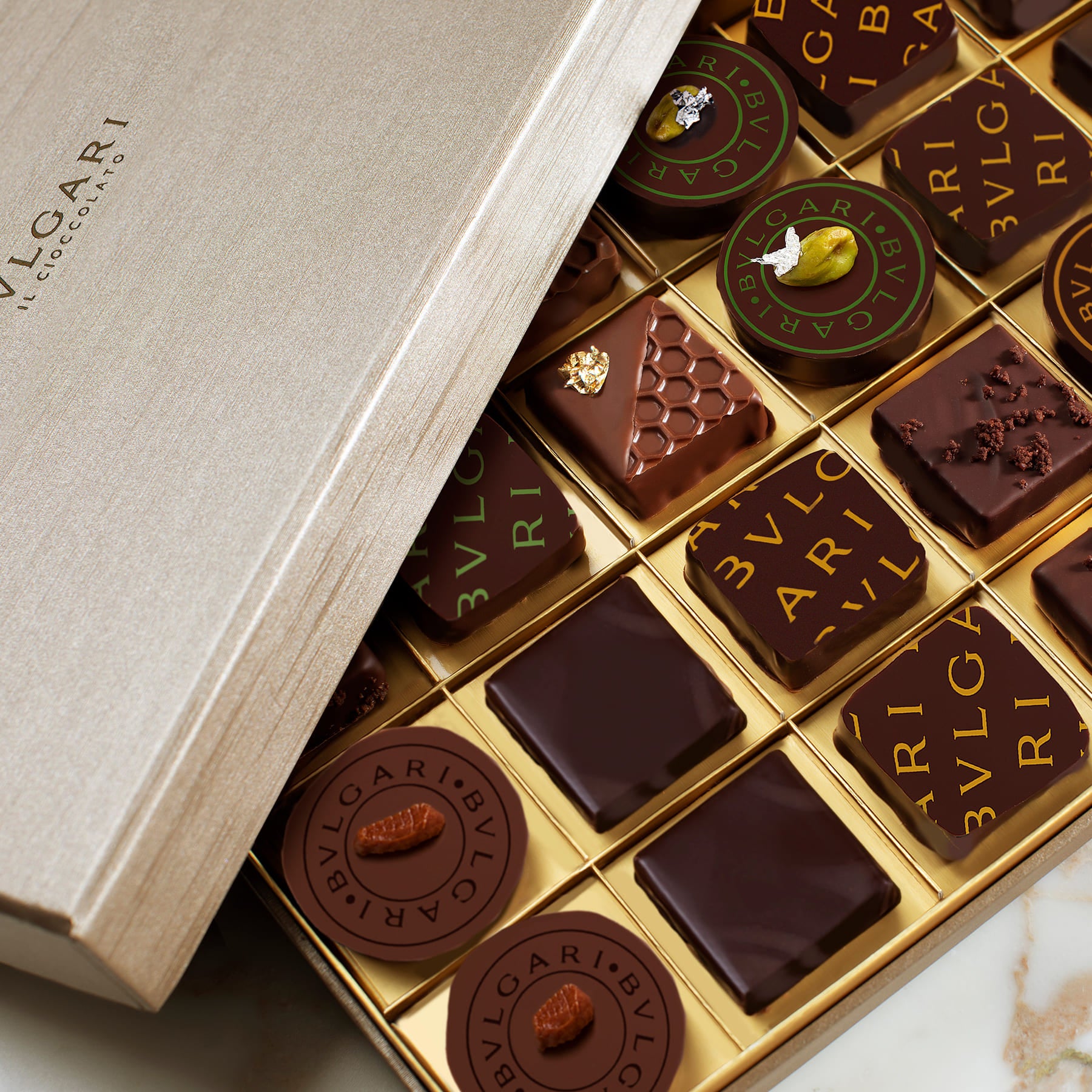 Bulgari chocolate box with various chocolates with Bulgari logo printed in gold and green made with chocolate transfer sheets for magnetic molds 